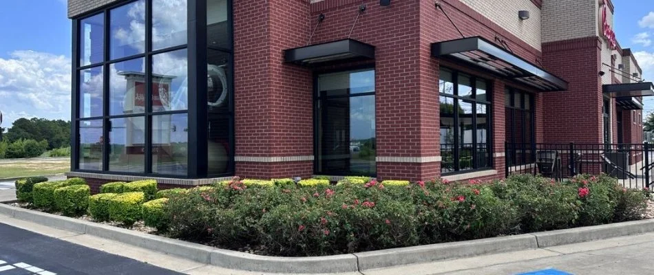 Commercial building in Muscogee County, GA, with shrubs and flowers.