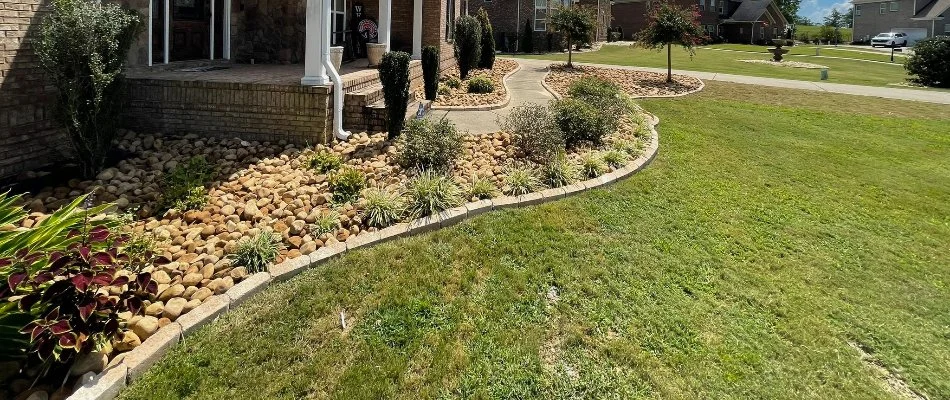 Grass beside a landscape in Phenix City, AL, with rocks and plants.