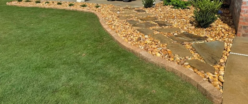 Manicured grass and neat landscaping in Columbus, GA, with rocks and plants.