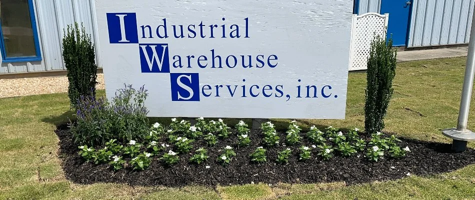 Business sign in Ladonia, AL, with mulched landscape and flowers.