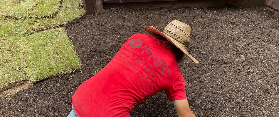 Worker prepping the soil for sod installation in Columbus, GA.