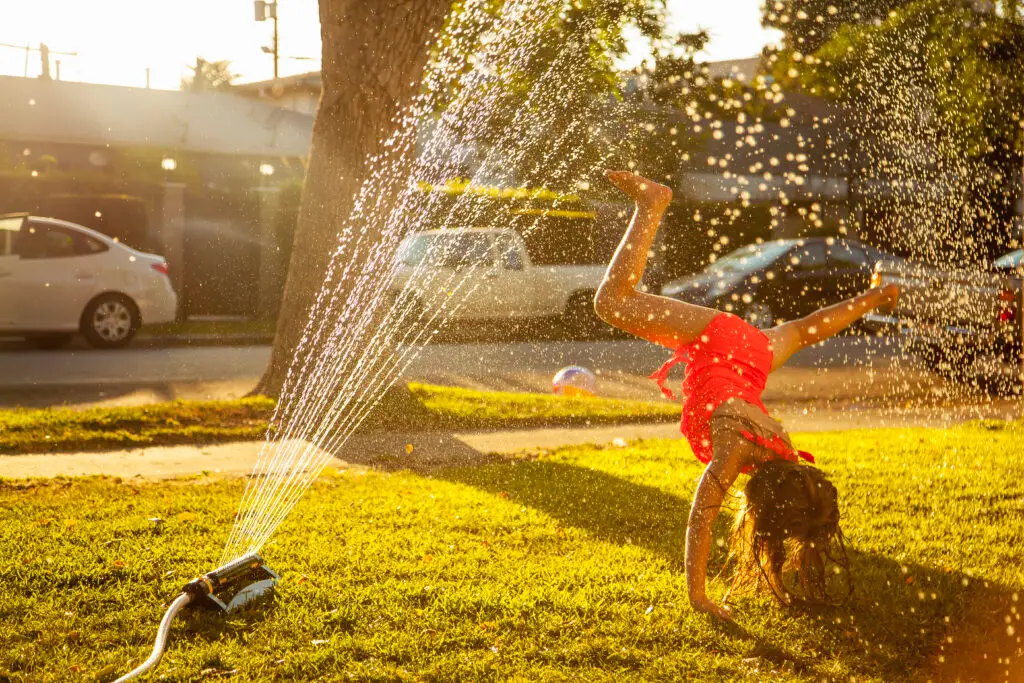 Girl playing in a sprinkler